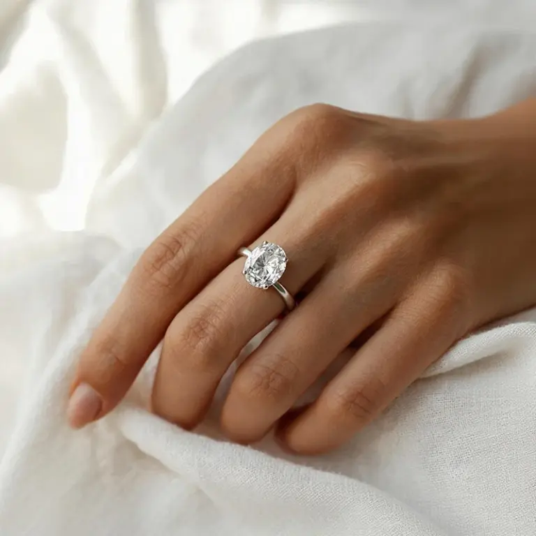 Oval diamond solitaire engagement ring worn on hand, showing the elongating effect on the finger — Provence Jewellery