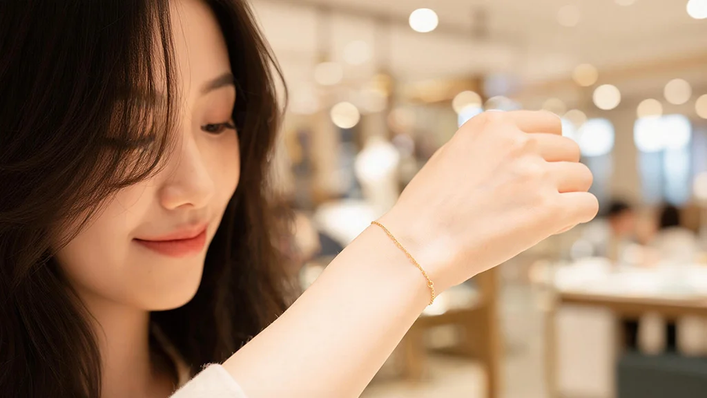 A client admiring her newly welded permanent gold bracelet on her wrist