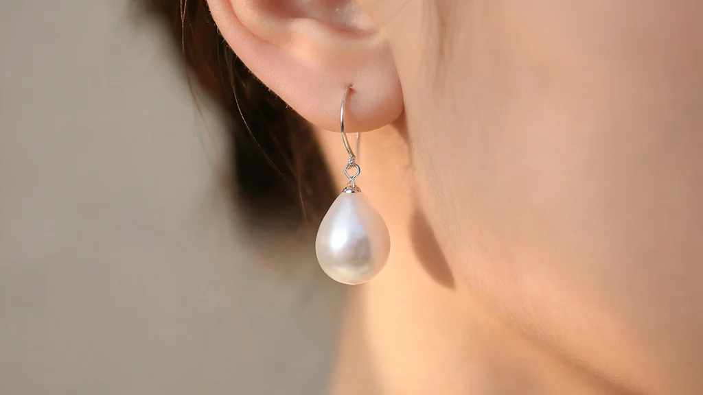 Pearl drop earring hanging below the earlobe