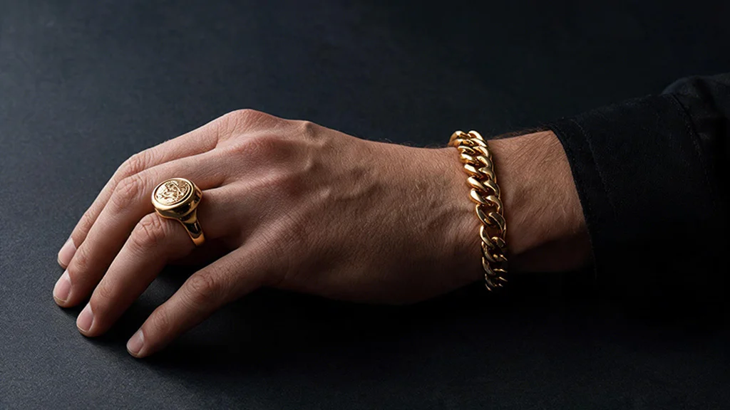 Men's gold chain bracelet and signet ring, representing the men's jewelry niche
