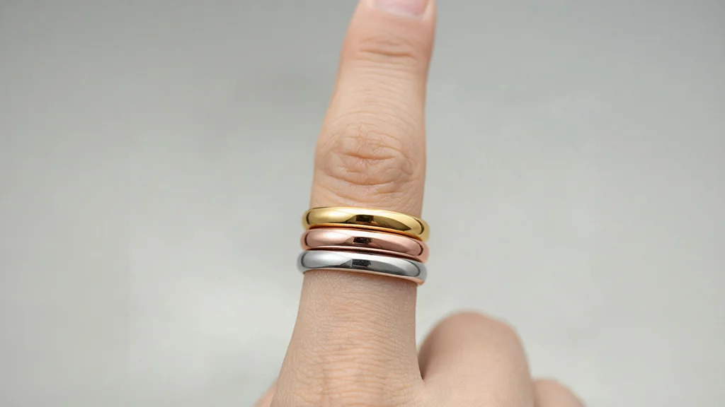 Mixed metal ring stack in silver, rose gold, and yellow gold on neutral undertone skin
