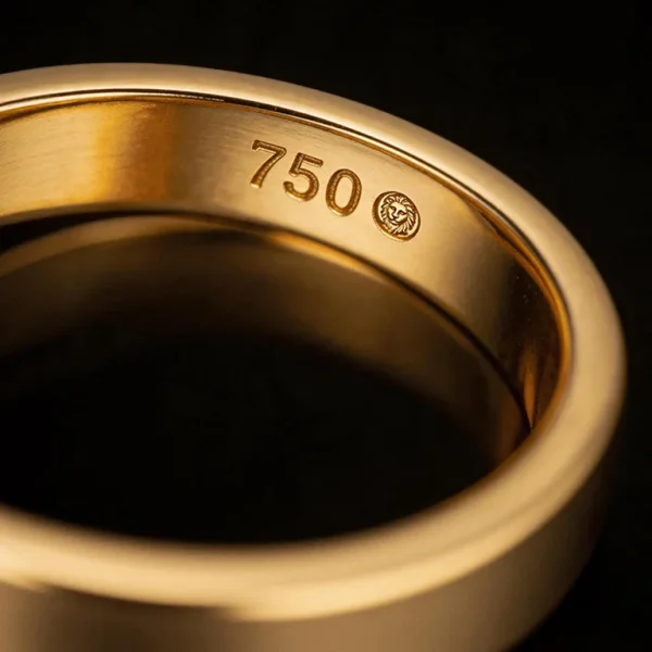 Close up of a 750 hallmark stamped inside a gold ring band, indicating 18K gold with 75% pure gold content